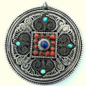 Tibetan amulet pendant Inlaid with coral and turquoise stones.
