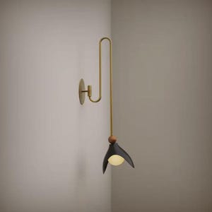 May include: A contemporary wall sconce with a brass finish and a black shade. The sconce has a curved arm and a small, round wooden accent. The light fixture emits a warm, inviting glow.