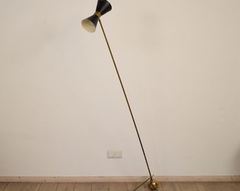 May include: A brass floor lamp with a black and white double-shade. The lamp has a long, thin arm and a round base.
