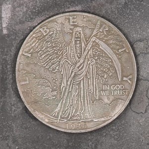 Könnte beinhalten: Eine silberne Münze mit einer geflügelten Figur mit einer Sense und einer Kapuzenrobe. Die Münze trägt die Inschrift "IN GOD WE TRUST" und das Jahr 1934. Die Münze liegt vor einem strukturierten, grauen Hintergrund.