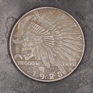 Puede incluir: Una moneda de plata con la imagen de un nativo americano con un tocado. La moneda dice "Liberty" en la parte superior, "In God We Trust" en la parte inferior y "1923" en el centro.