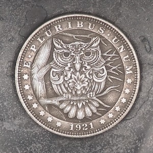 Könnte beinhalten: Eine Silbermünze mit einem Eulenmotiv und der Aufschrift "E Pluribus Unum" und "1921".