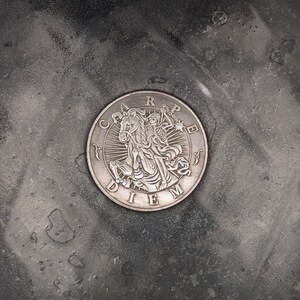 May include: A silver coin with the Latin phrase "Carpe Diem" and a depiction of a skeleton riding a horse.