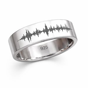 Könnte beinhalten: Ein silberner Ring mit einem schwarzen Schallwellenmuster. Der Ring hat ein flaches, breites Band mit dem eingravierten Text "925". Das Schallwellenmuster besteht aus einer Reihe vertikaler Linien unterschiedlicher Höhe.