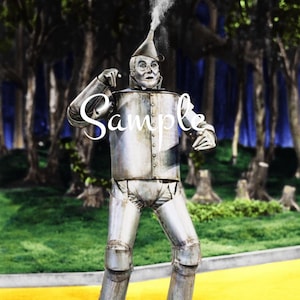 Op de afbeelding: Een metallic zilveren robotfiguur met een trechtervormige hoed waar een pluim witte rook uit komt. Het figuur heeft een cilindrische romp met zichtbare klinknagels en een gelederd pantser, staand op een geel pad met het woord Sample eroverheen.