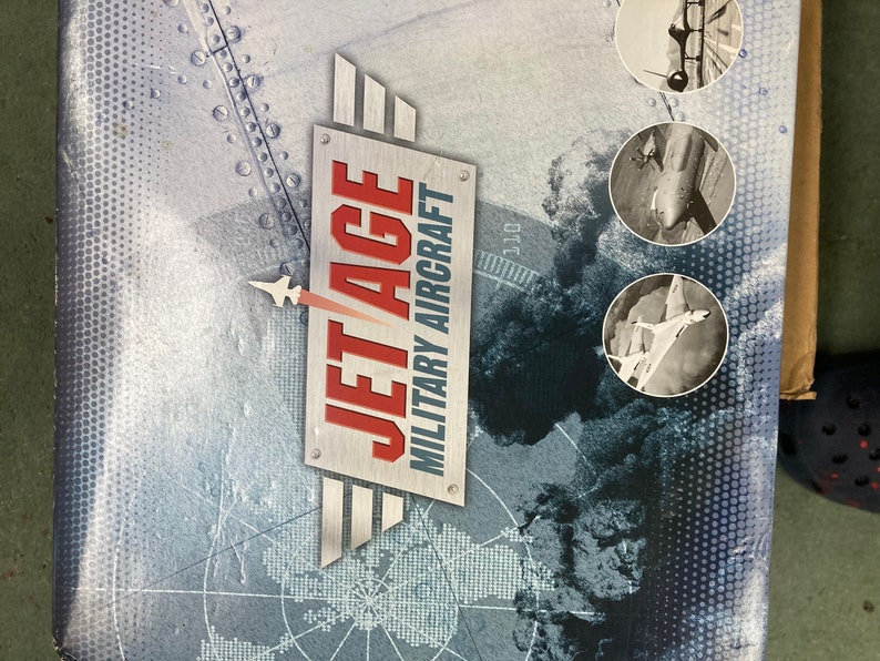 May include: A box with a gray and white background featuring a world map and the text "JET AGE MILITARY AIRCRAFT". The box has three circular images of military aircraft.