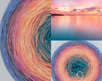 May include: A skein of yarn with a gradient of colors, starting with a deep blue, transitioning to a light pink, then a peach, and finally a teal green. The yarn is wound into a ball shape, and the colors are arranged in concentric circles.