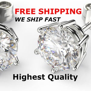 May include: A pair of silver stud earrings with a clear round stone set in a prong setting. The earrings are marked "S925" on the back.