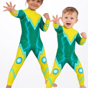 Puede incluir: Conjuntos de dos piezas de camiseta de manga larga y leggings con un patrón de rayos verde y amarillo y detalles circulares azules. Las prendas muestran el texto MAX(XX)ART y una insignia circular que dice SOLD SEPARATELY.