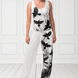 May include: White tank top and pants set featuring a black raven design. The sleeveless top and wide-leg pants have a repeating pattern of flying ravens and abstract black brushstrokes. The text "MAX(XX)ART" is visible in the top left corner.