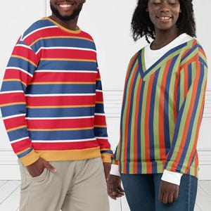 Könnte beinhalten: Zwei Personen tragen bunt gestreifte Sweatshirts. Eines hat horizontale Streifen in Rot, Blau und Gelb. Das andere hat vertikale Streifen in Orange, Grün und Blau. Der Text "MAX(XX)ART" befindet sich in der oberen linken Ecke.