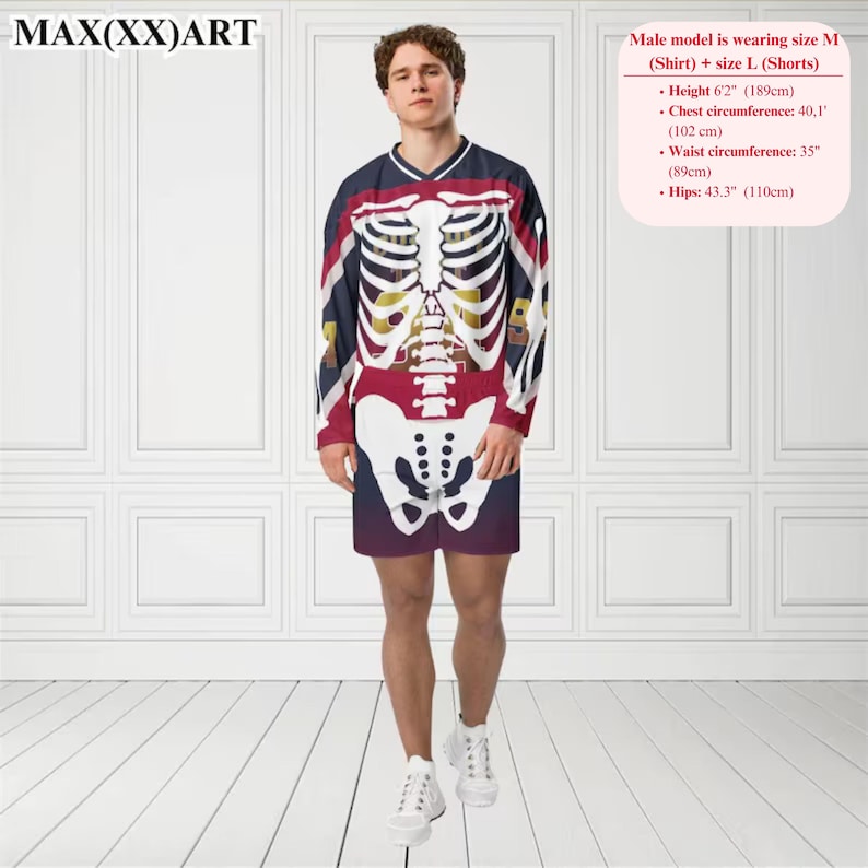 K&ouml;nnte beinhalten: Eine Person tr&auml;gt ein lang&auml;rmeliges Hemd und Shorts mit einem Skelett-Grafikdruck. Das Hemd und die Shorts sind rot, wei&szlig; und blau. Das Model steht vor einer wei&szlig;en Wand.