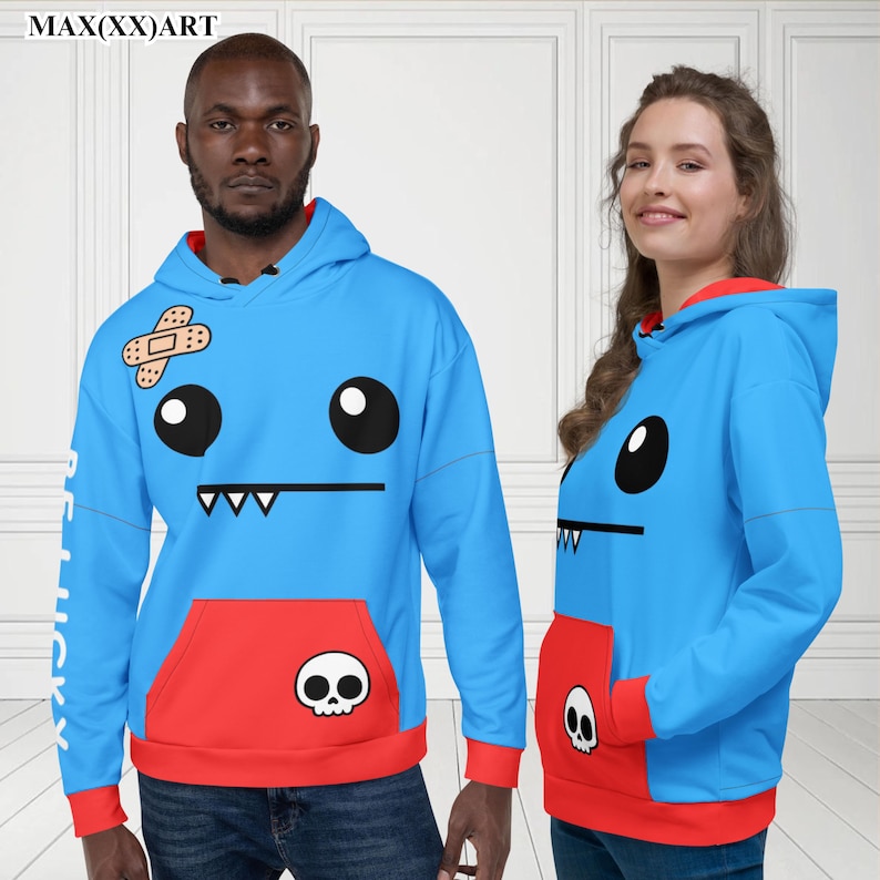May include: Two blue hoodies with a cartoon face design. The hoodie has a red pocket with a skull graphic. One hoodie has a bandage on the face. The text "BE LUCKY" is on the sleeve.
