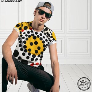 以下が含まれることがあります： 黄色、黒、白、赤のドット柄の半袖Tシャツ。黒いパンツとグレーの野球帽を着用しています。左上に「MAX(XX)ART」の文字。右下に「SOLD SEPARATELY」の文字。