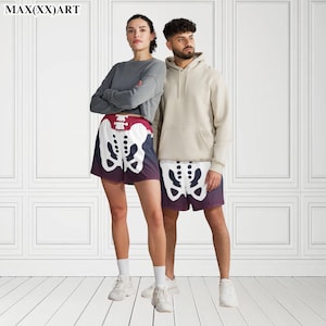 K&ouml;nnte beinhalten: Zwei Personen tragen passende Shorts mit Skelett-Print. Die Shorts sind schwarz mit wei&szlig;en Skelettknochen und einem roten Bund. Die Person links tr&auml;gt ein graues Langarmshirt. Die Person rechts tr&auml;gt einen beigen Hoodie.