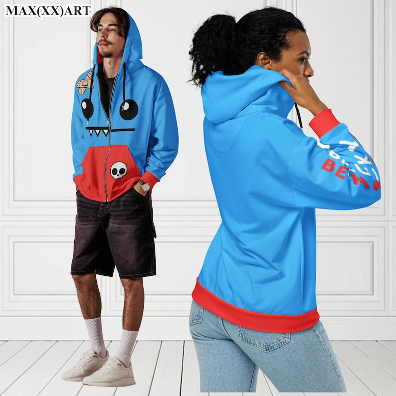 May include: Two blue hoodies with red accents. One hoodie features a cartoon monster design with a skull and crossbones. The other hoodie has the text "BE KIND" on the sleeve.
