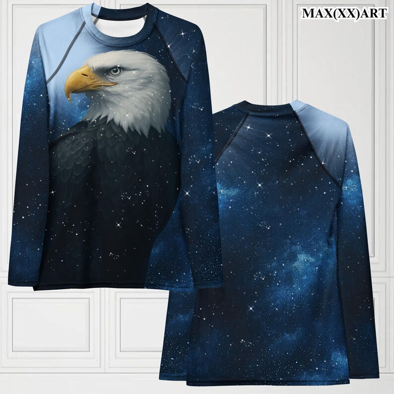 Puede incluir: Camiseta de manga larga con una ilustraci&oacute;n detallada de una cabeza de &aacute;guila calva sobre un cielo estrellado. La camiseta tiene un esquema de color azul y negro, con el texto "MAX(XX)ART" en la esquina superior derecha.
