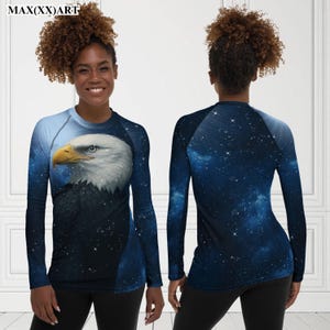 Puede incluir: Camiseta deportiva de manga larga con una ilustraci&oacute;n detallada de la cabeza de un &aacute;guila calva. La camiseta tiene un dise&ntilde;o de cielo estrellado azul y negro. El texto "MAX(XX)ART" est&aacute; en la parte superior.
