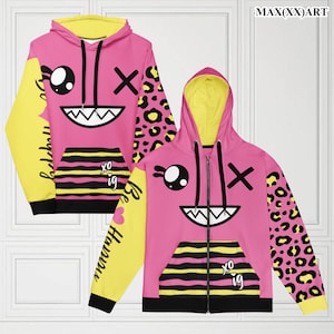 May include: Pink and yellow hoodie with a cartoon face graphic, black stripes, and leopard print. The hoodie has a zip fastening and a hood.