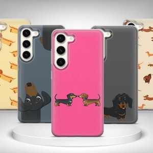 Könnte beinhalten: Eine Sammlung von Handyhüllen mit Dackel-Designs. Die Hüllen sind in verschiedenen Farben erhältlich, darunter Pink, Gelb, Grau und Beige. Einige Hüllen haben sich wiederholende Muster von Dackeln, während andere einzelne Hundeillustrationen zeigen.