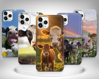 May include: A collection of phone cases featuring images of cows in various settings. The cases display close-up shots of cows in fields, with some showcasing a rainbow and others with flowers. The cases are in different colors.