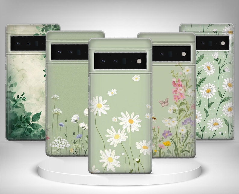 May include: Five phone cases with floral patterns. The cases have a pale green base with designs of daisies, wildflowers, and green leaves. The cases are displayed on a white, circular platform. The cases are for a mobile phone.