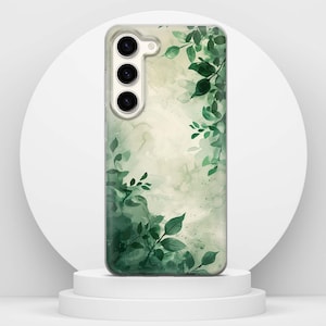 May include: A phone case with a watercolour design of green leaves and foliage. The case has a clear background with a soft, blurred effect. The leaves are in varying shades of green, creating a natural, botanical theme.
