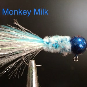 May include: A blue and white fly fishing lure with a blue glitter bead. The lure is called "Monkey Milk".