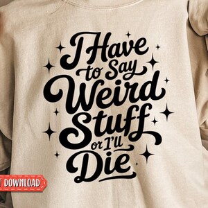 May include: A beige crewneck sweatshirt featuring black text that reads I Have to Say Weird Stuff or I'll Die, surrounded by small four-pointed star graphics. The design is centered on the chest of the long-sleeved garment.