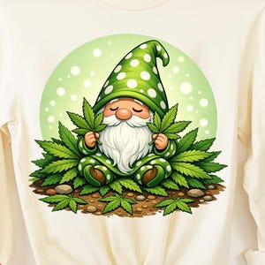 May include: Cream-colored long-sleeve shirt featuring a whimsical gnome design. The gnome, with a white beard and green polka-dot hat, is surrounded by green cannabis leaves. The shirt has a tied knot at the waist and the words "INSTANT DOWNLOAD" and "DIGITAL DOWNLOADS" are visible.