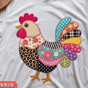 May include: A white t-shirt featuring a large, colorful rooster graphic composed of various patterned patches, including leopard print, floral, polka dot, plaid, and striped designs. The rooster has a bright red comb and wattle with yellow feet.