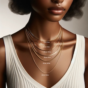 May include: A close-up of a model wearing six different gold chain necklaces, each with a different length. The lengths are labeled in inches and centimeters.