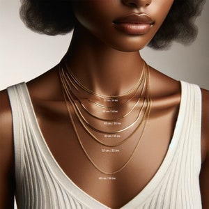 May include: A close-up of a model wearing six different gold chain necklaces, each with a different length. The lengths are labeled in inches and centimeters.