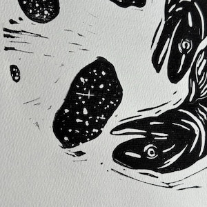 K&ouml;nnte beinhalten: Schwarz-Wei&szlig;-Linolschnitt mit Fischen und abstrakten Formen. Die Fische sind mit detaillierten Linien und Kurven dargestellt, w&auml;hrend die Formen eine gesprenkelte Textur aufweisen. Der Druck befindet sich auf einem wei&szlig;en Hintergrund.