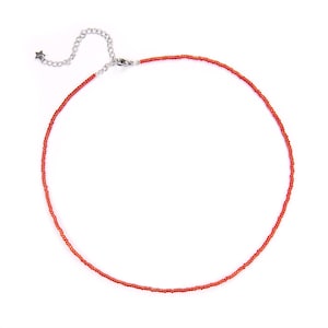 May include: A red beaded choker necklace with a silver clasp.