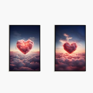 Op de afbeelding: Twee ingelijste prints van een roze hartvormige wolk in een blauwe lucht met witte wolken. De hartvormige wolk bevindt zich in het midden van de afbeelding en is omringd door witte wolken. De lucht is lichtblauw.