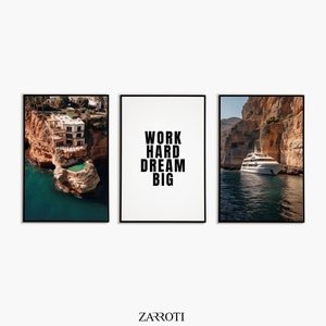 Op de afbeelding: Drie ingelijste prints, één met een foto van een wit huis met een zwembad op een klif met uitzicht op de oceaan, één met een foto van een witte jacht in een baai en één met de tekst "WORK HARD DREAM BIG" in zwart.