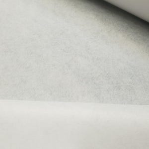 Może przedstawiać: Biała tkanina usztywniająca, materiał termoplastyczny stosowany do stabilizowania i wzmacniania tkanin.