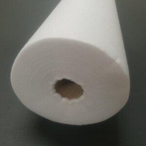 Może przedstawiać: Biała rolka z wł&oacute;kniny, rodzaj materiału często używanego do rękodzieła i projekt&oacute;w DIY.