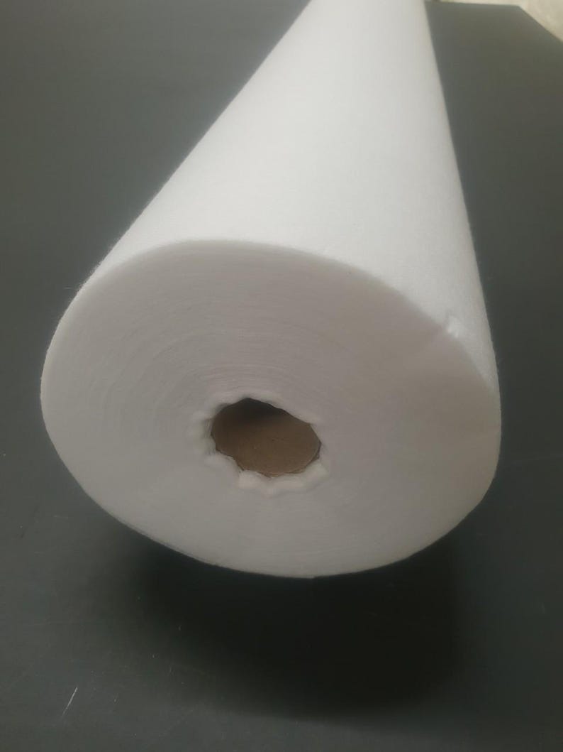 Może przedstawiać: Biała rolka z wł&oacute;kniny, rodzaj materiału często używanego do rękodzieła i projekt&oacute;w DIY.