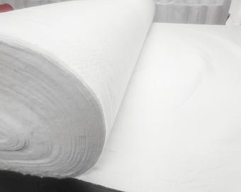Może przedstawiać: Biały rulon tkaniny, rozwinięty, aby odsłonić miękki, biały materiał. Tkanina jest ciasno zwinięta i wydaje się być rodzajem materiału nietkanego.