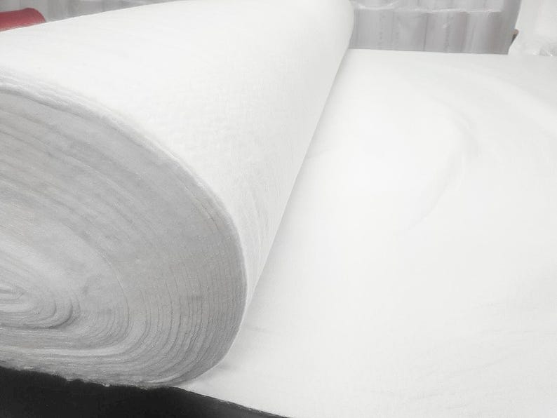 K&ouml;nnte beinhalten: Eine wei&szlig;e Stoffrolle, die entrollt ist und das weiche, wei&szlig;e Material zeigt. Der Stoff ist fest gewickelt und scheint eine Art Vliesstoff zu sein.