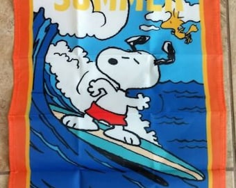 May include: An orange and blue summer themed garden flag featuring Snoopy riding a surfboard with the word "SUMMER" in yellow letters.
