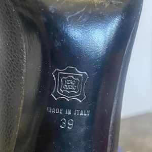 Może przedstawiać: Czarna sk&oacute;rzana podeszwa buta z napisem "MADE IN ITALY" i numerem "39". Podeszwa posiada r&oacute;wnież pieczęć z napisem "VERO CUOIO".