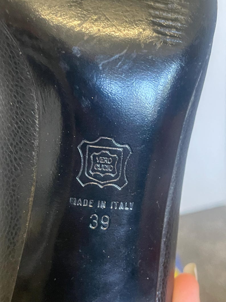 Może przedstawiać: Czarna sk&oacute;rzana podeszwa buta z napisem "MADE IN ITALY" i numerem "39". Podeszwa posiada r&oacute;wnież pieczęć z napisem "VERO CUOIO".