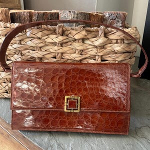 Bolso de mano vintage para mujer, años 50, de piel de cocodrilo en color naranja y marrón, con asa superior y cierre de broche de latón.
