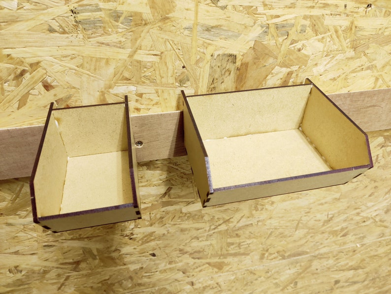 May include: Two wooden storage boxes with brown stained edges, mounted on a wall. The boxes are empty and ready to be filled with items.