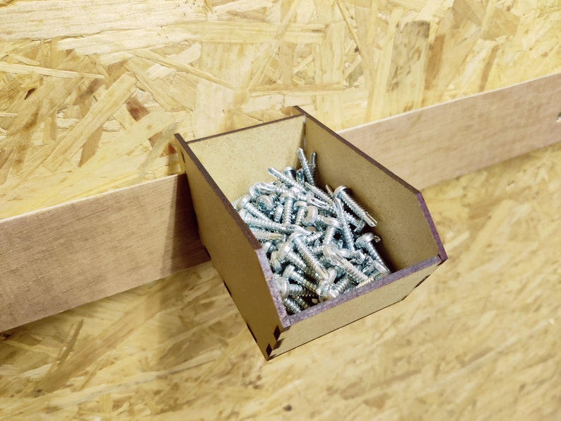 May include: A wooden wall-mounted organizer with a small compartment filled with silver screws.
