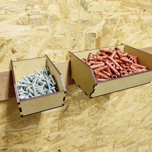 May include: Two wooden storage bins with a brown finish. The bin on the left is filled with silver screws. The bin on the right is filled with red plastic anchors.