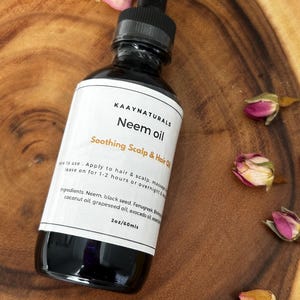 May include: A 2-ounce bottle of Neem oil for soothing scalp and hair. The bottle is labeled "KAAYNATURALS Neem oil Soothing Scalp & Hair Oil" and lists the ingredients: Neem, black seed, Fenugreek, coconut oil, grapeseed oil, avocado oil, and essential oils.